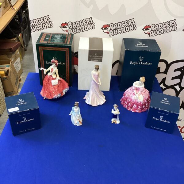 Royal Doulton figures displayed on a blue table, collectible porcelain.