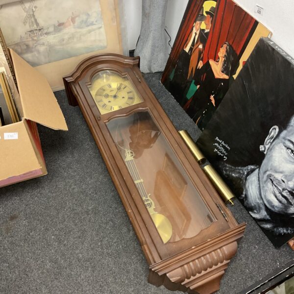 Large chiming wall clock with pendulum and weights, vintage style.