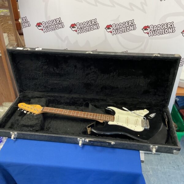 Black Encore electric guitar in a hard case, musical instrument.