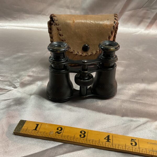 Antique pocket binoculars in a worn leather case.