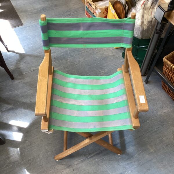 Vintage striped folding director’s chair with wooden frame.
