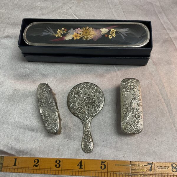Antique silver plate dressing table set with floral details.