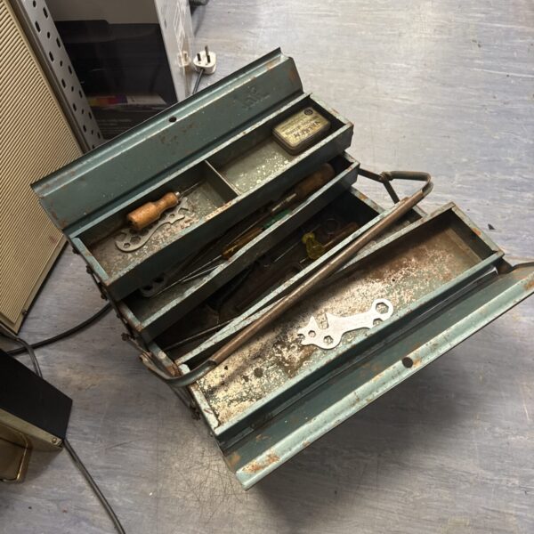 Open vintage cantilever toolbox filled with tools.