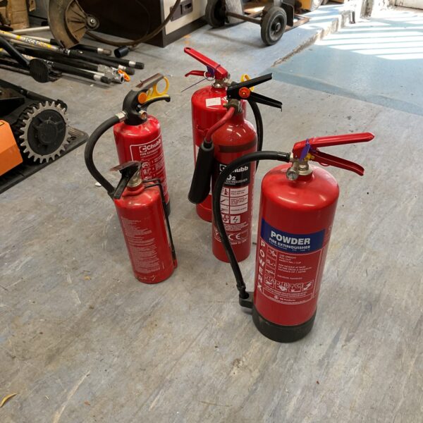 Lot of five vintage red fire extinguishers for collectors.