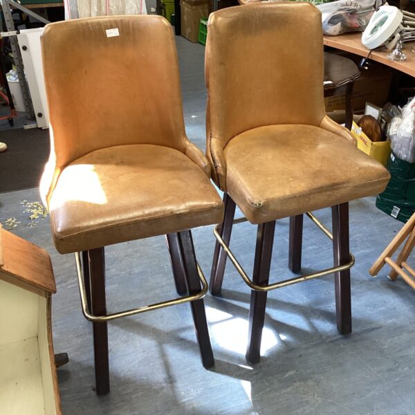 Pair of vintage leather bar stools with wooden frames.