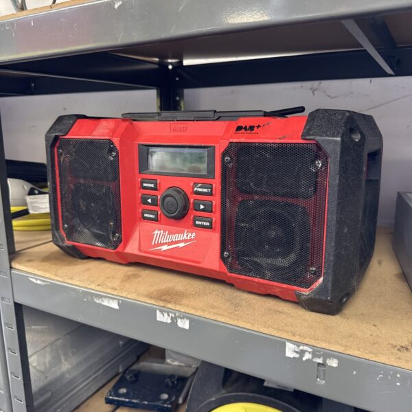 Red Milwaukee M18 cordless site radio with damaged screen.