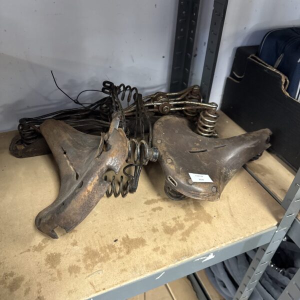 Vintage bicycle saddles lot including a Lycett example, showing wear.