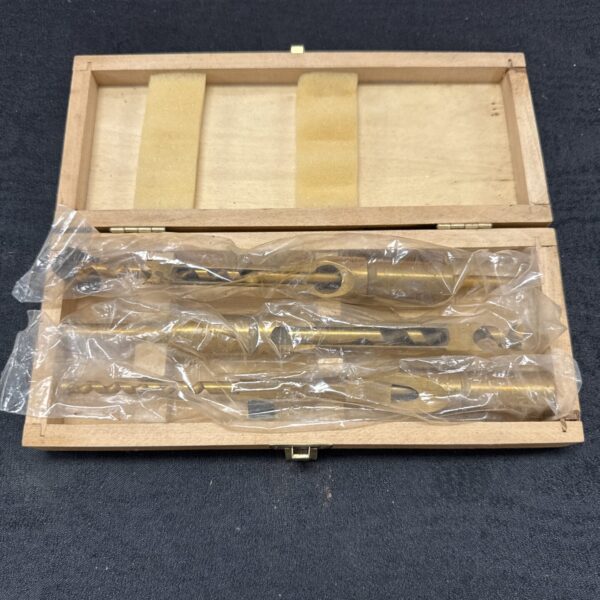 Vintage pillar drill bits in a wooden storage box.