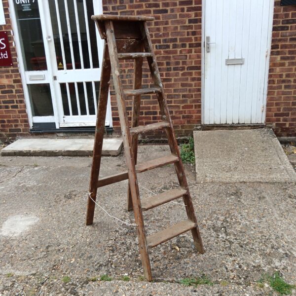 Vintage wooden step ladder with four steps, rustic charm.