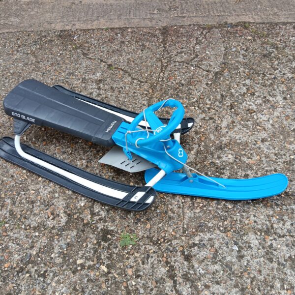 Red and black Hamax Sno Blade sledge for winter snow play.