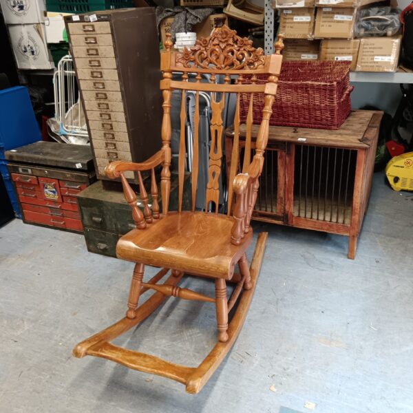 Intricate carving on antique wooden rocking chair, a beautiful collectible.