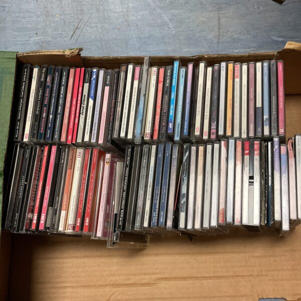 Large collection of classical music CDs in a cardboard box.