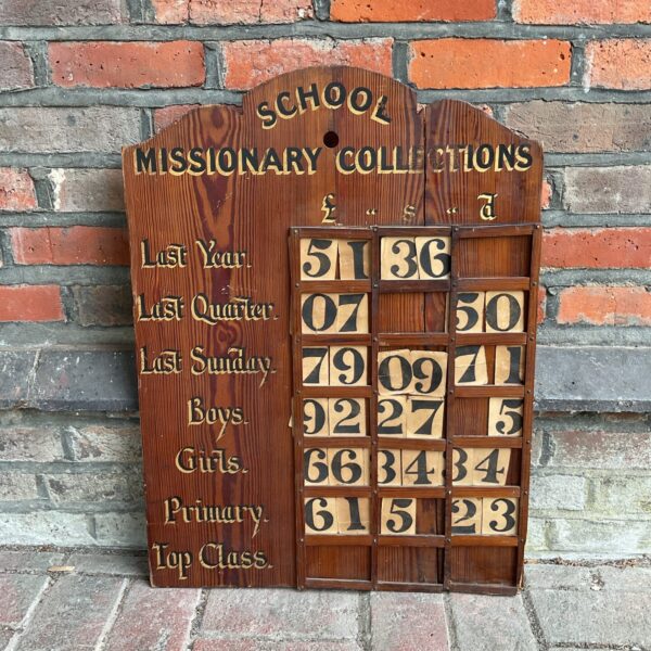 Vintage school missionary collection board with spaces for donations.