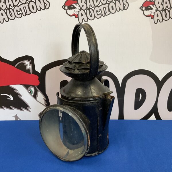 Antique British railway lantern with protective cage.