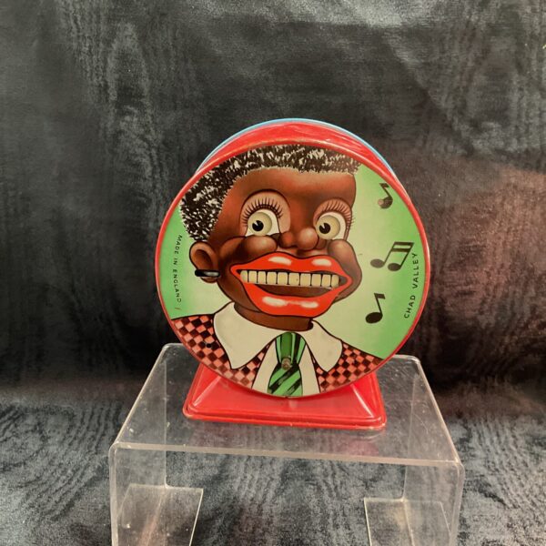 Vintage Chad Valley minstrel money box with musical notes.