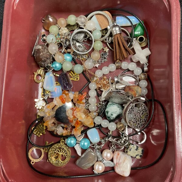 Tray of assorted jewellery, beads, and pendants for crafting.