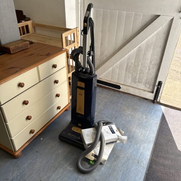 Sebo X4 upright vacuum cleaner with extension hose and spare bags.