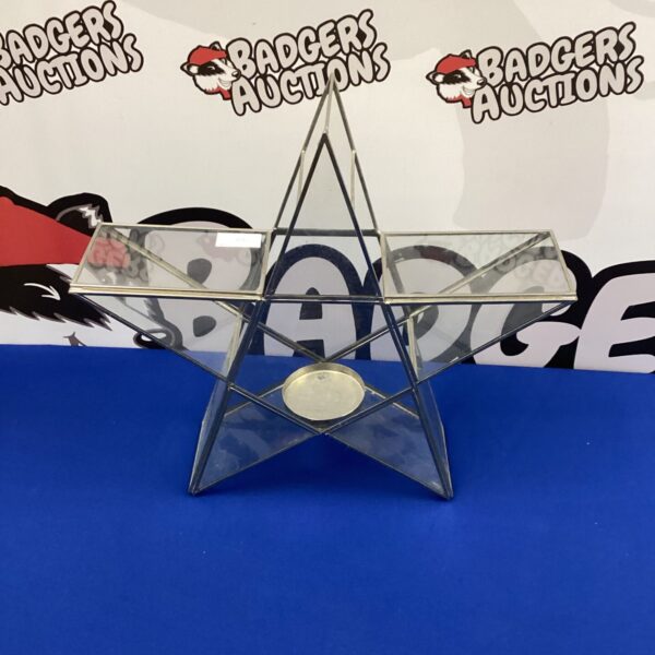 Clear glass star tea light holder for decorative lighting.