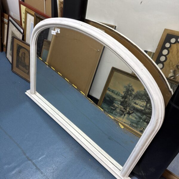 Large antique overmantle mirror with ornate frame and reflective surface.