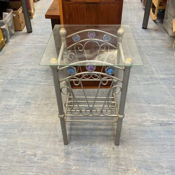 Vintage metal framed glass table with decorative details.