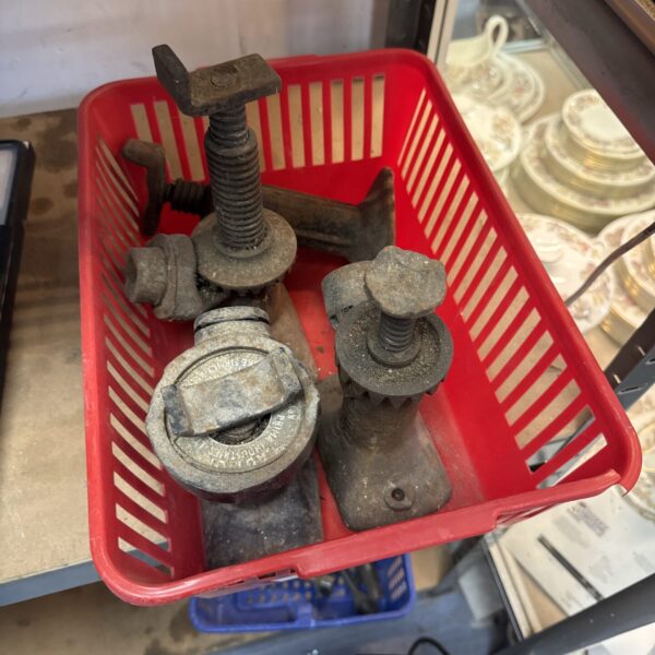 Lot of four vintage bottle jacks in a red crate.