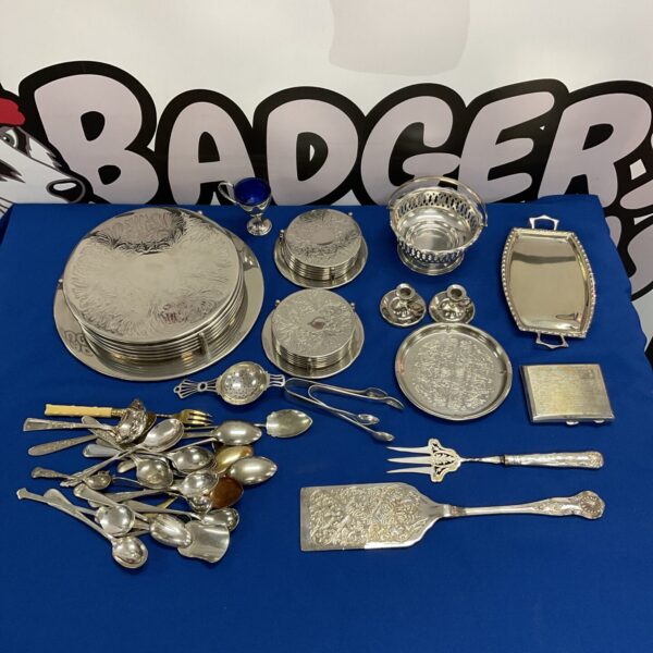 Vintage silver plate coasters and cutlery lot on display.