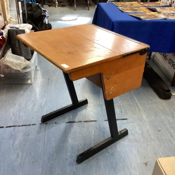 Vintage wooden school desk with sloped writing surface.