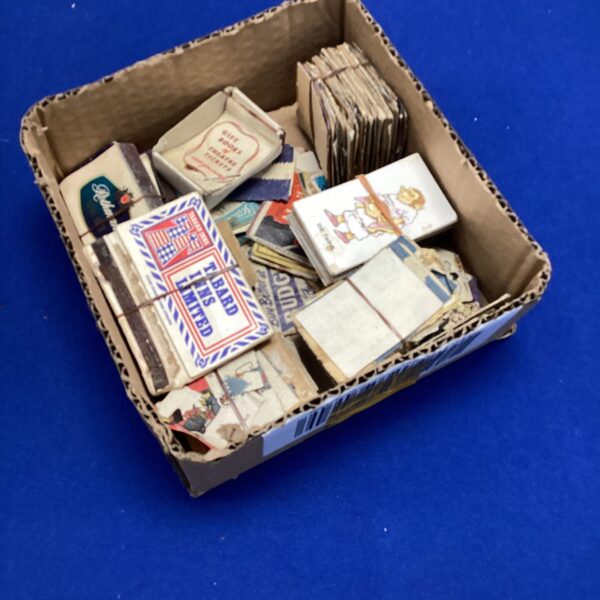 Vintage matchbox collection displayed in a cardboard box.