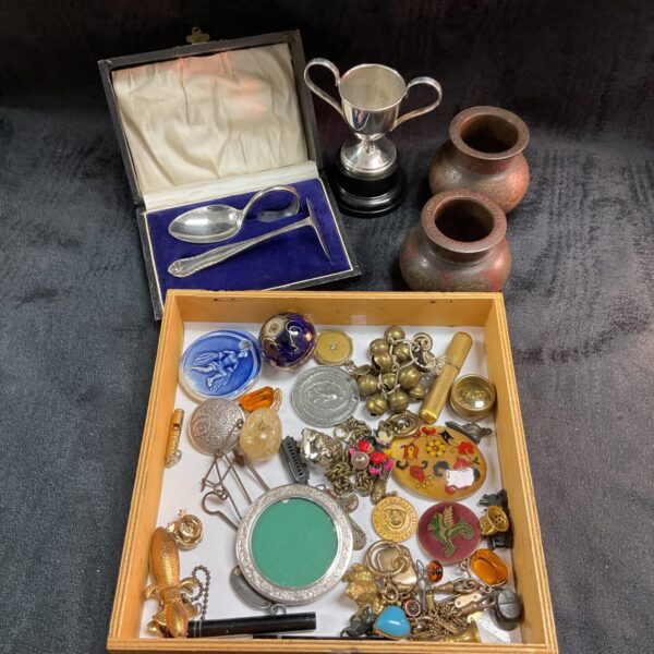 Overhead view of a mixed curios tray with vintage collectibles.