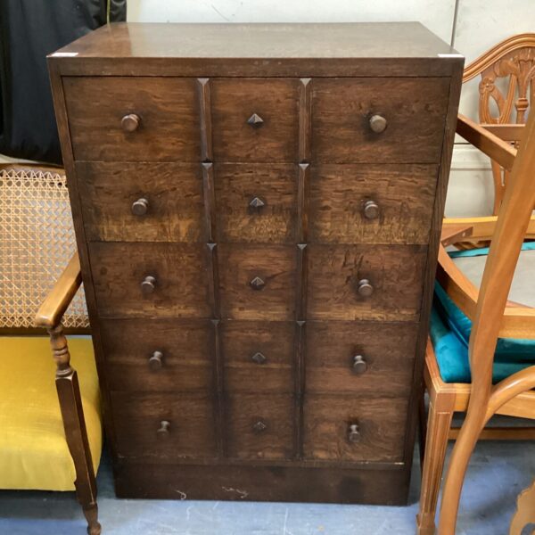 Dark wood mid-century gothic chest of drawers with elongated pulls.