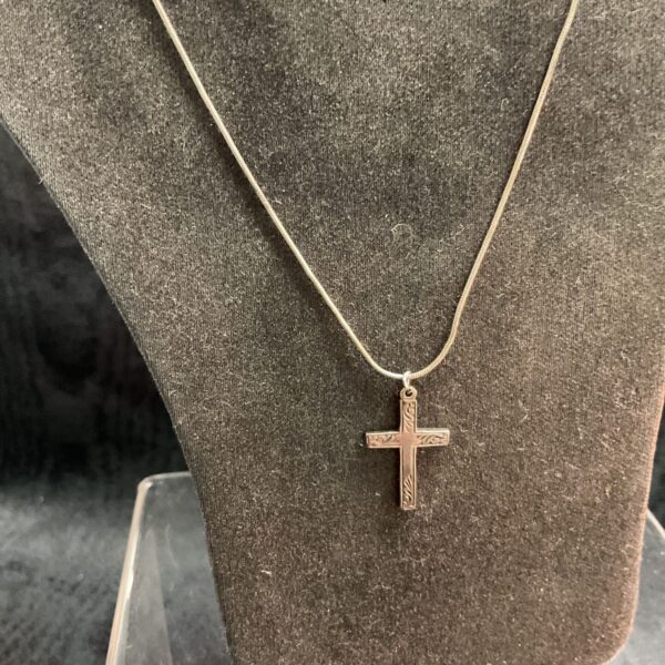 Sterling silver cross pendant on a snake chain necklace.