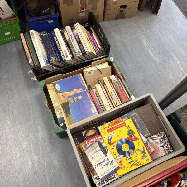 Three crates filled with assorted vintage and used books.