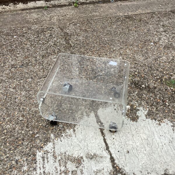 Clear acrylic TV stand with castors for modern display.