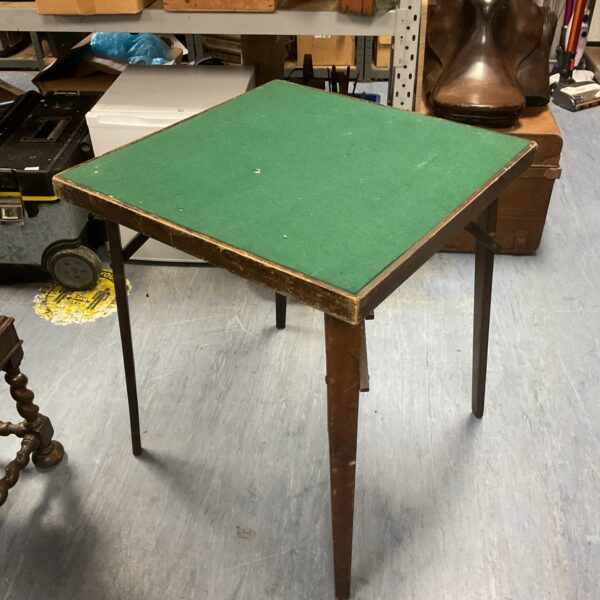 Vintage folding card table with green felt surface.