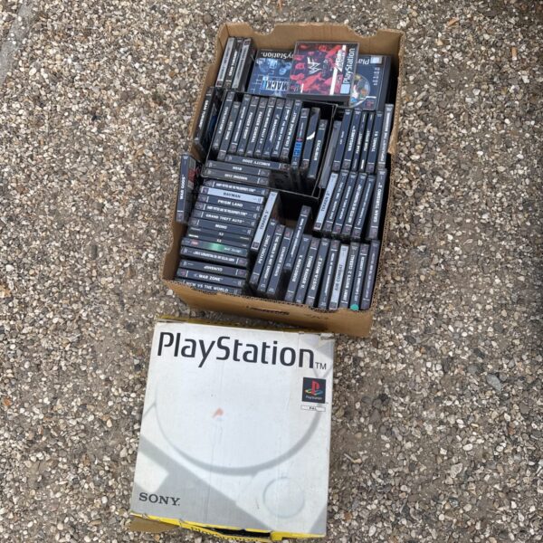 Vintage Sony PlayStation console with a tray of games.