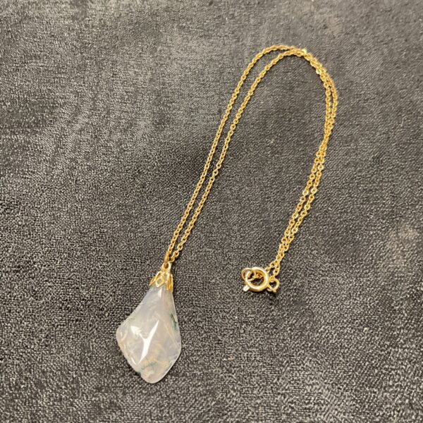 Delicate quartz pendant necklace with visible plant inclusions.