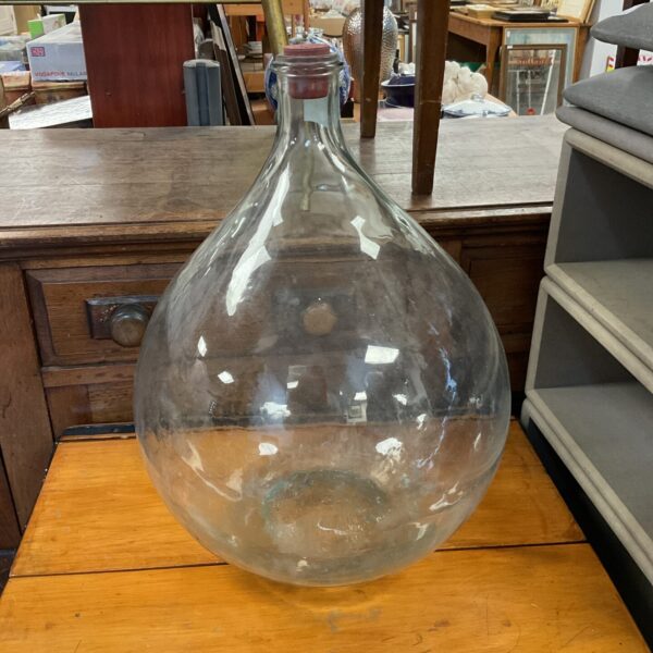 Large vintage glass carboy bottle with a narrow neck.