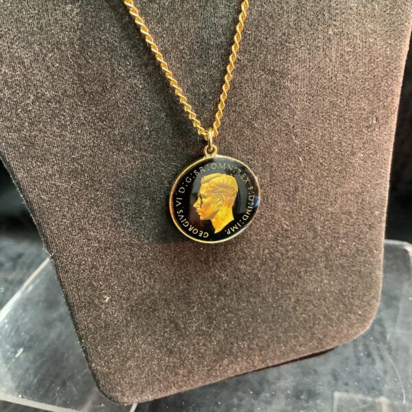 Close-up of vintage George VI farthing necklace with gold chain.