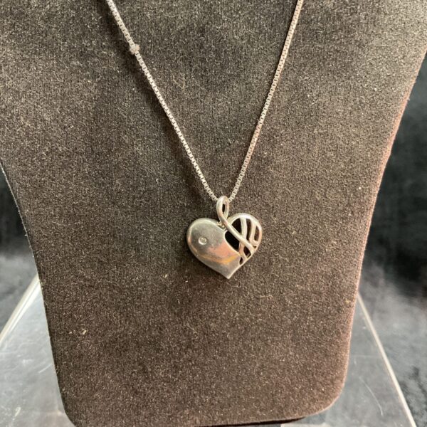 Close-up of 925 silver diamond heart pendant necklace on a chain.