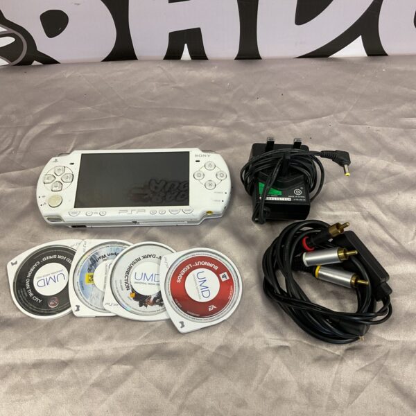 White Sony PSP console with games, retro handheld gaming system.