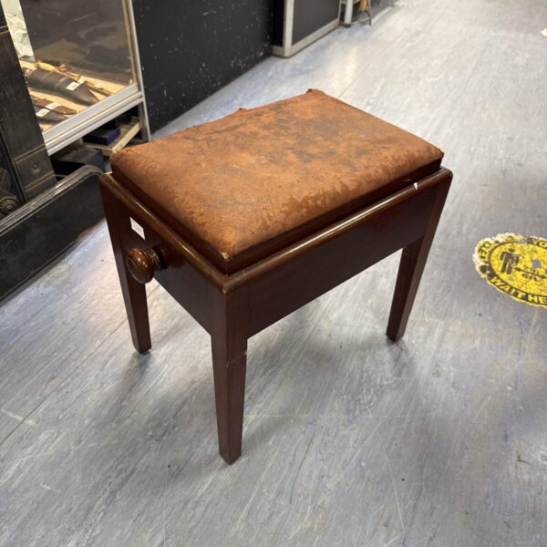 Side view of a vintage height adjustable piano stool.