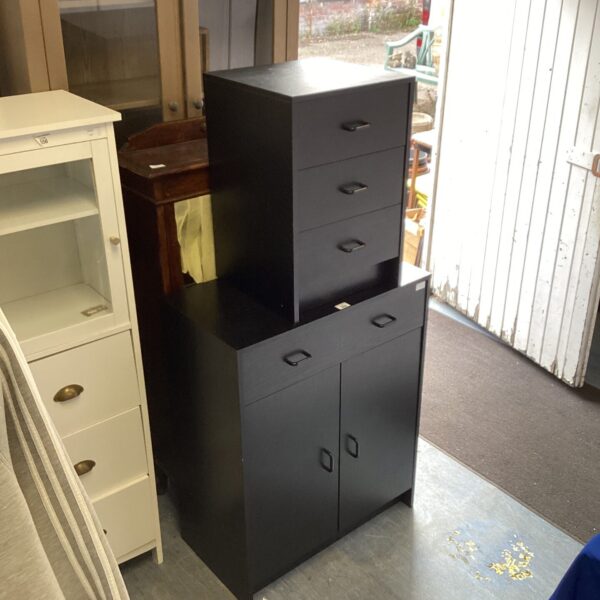 Black wood effect storage unit with drawers and cupboard.
