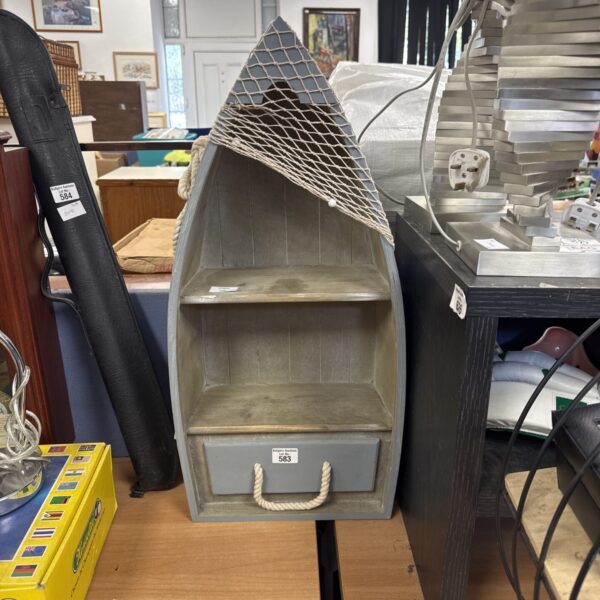 Front view of a vintage wooden sailboat shelf unit.