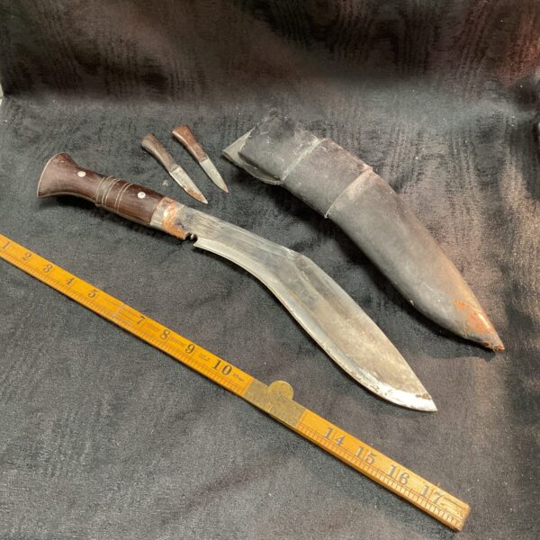 Traditional Indian Kukri knife with leather sheath, curved blade.