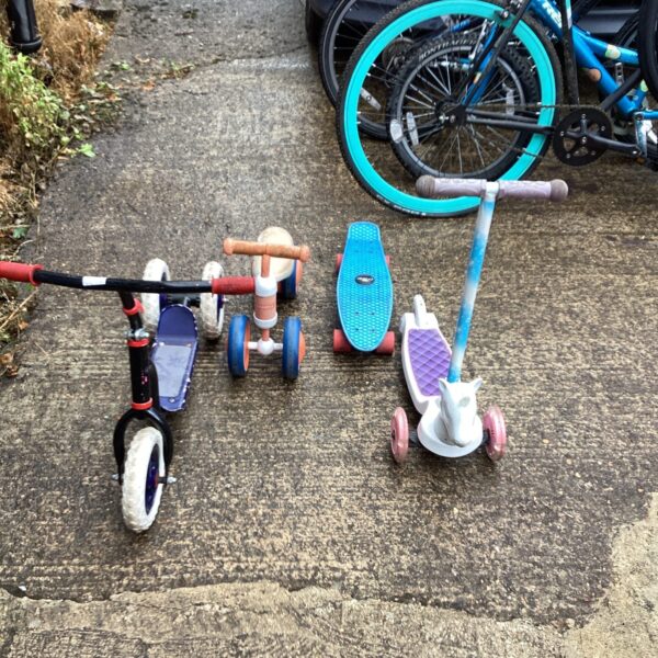 Lot of childrens bikes and skateboards for outdoor play.