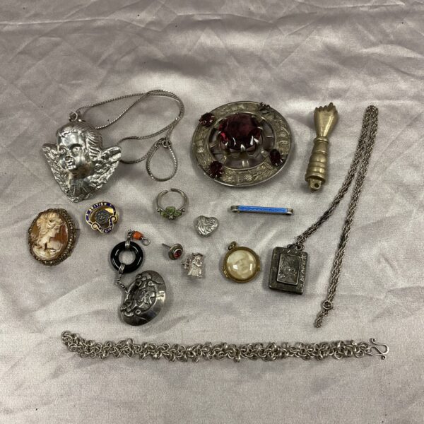 Vintage jewellery lot featuring a silver cherub pendant and Scottish brooch.