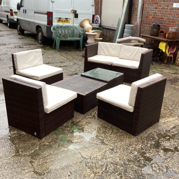 Raffia garden furniture set with sofa and armchairs on a patio.