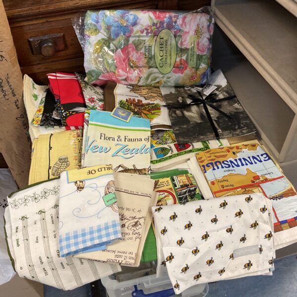 New floral tea towels and vinyl tablecloth in original packaging.