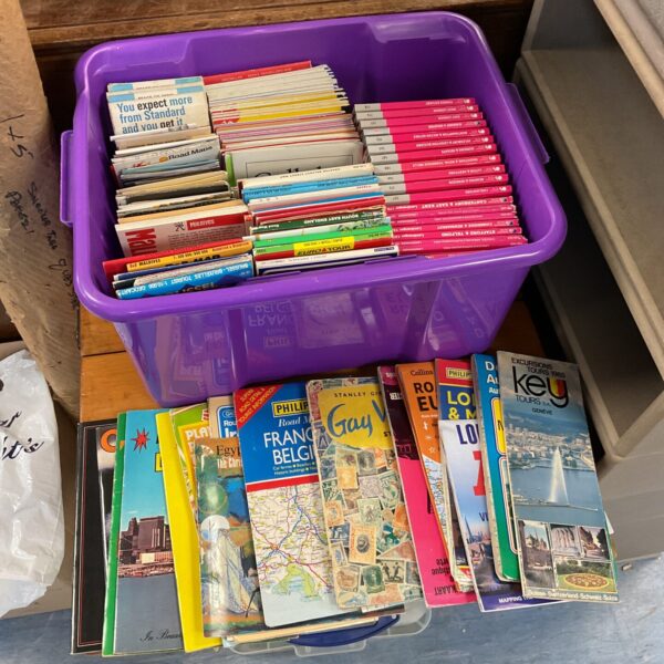 Stack of vintage European road maps and travel guides.