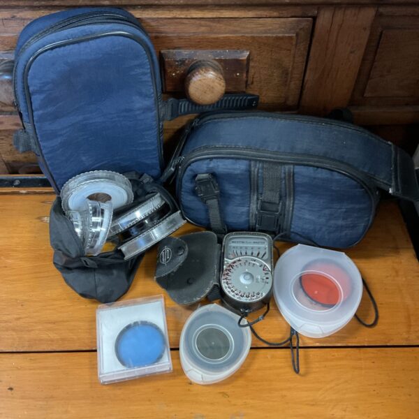 Vintage camera filters and a Weston light meter in a protective case.